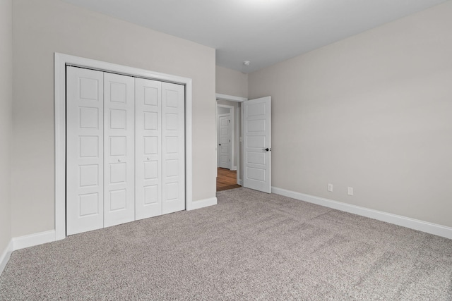 unfurnished bedroom with a closet and carpet flooring