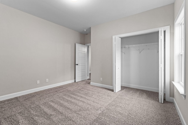 unfurnished bedroom featuring a closet and light carpet