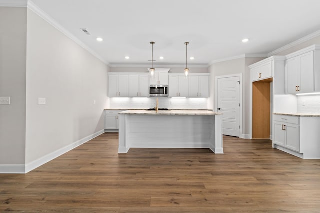 kitchen featuring white cabinetry, hanging light fixtures, decorative backsplash, dark wood-type flooring, and an island with sink