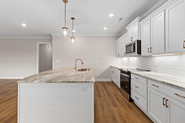 kitchen featuring pendant lighting, appliances with stainless steel finishes, white cabinetry, sink, and a center island with sink