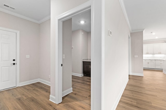 foyer featuring crown molding and light hardwood / wood-style floors