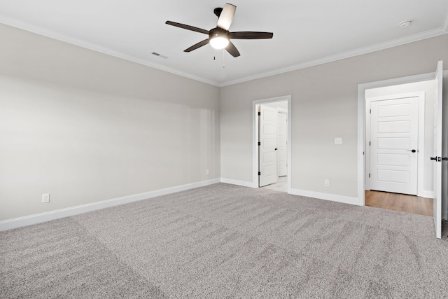 spare room with crown molding, ceiling fan, and light carpet