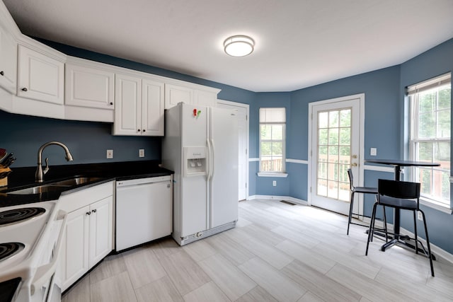 kitchen with white appliances, plenty of natural light, and sink