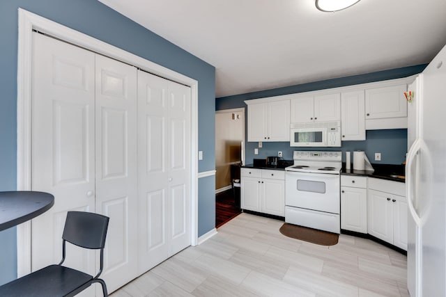 kitchen with light wood-type flooring, white appliances, and white cabinets