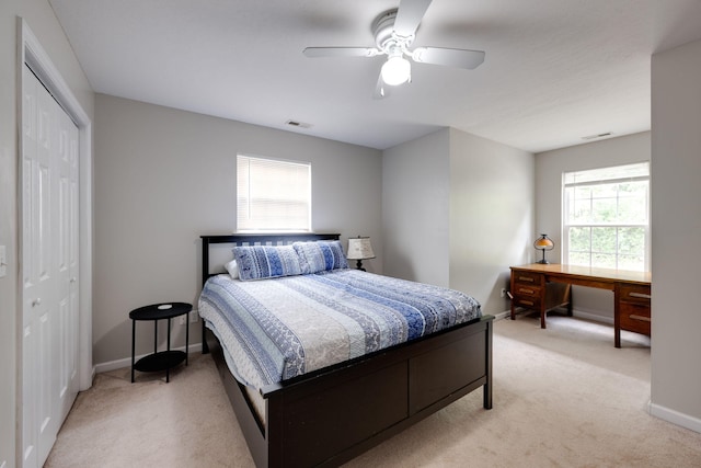 carpeted bedroom featuring ceiling fan and a closet