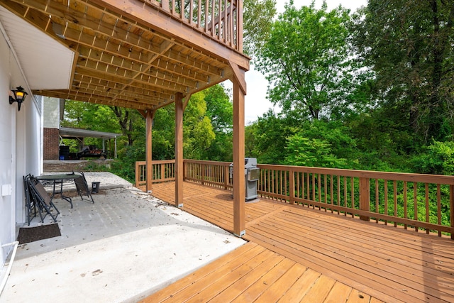 wooden deck featuring a grill and a patio area