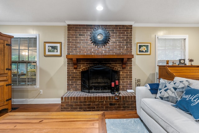 living room with hardwood / wood-style flooring, a brick fireplace, and crown molding