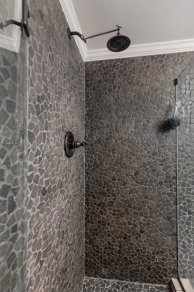 bathroom featuring a tile shower and crown molding