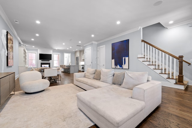 living room featuring dark hardwood / wood-style flooring and crown molding