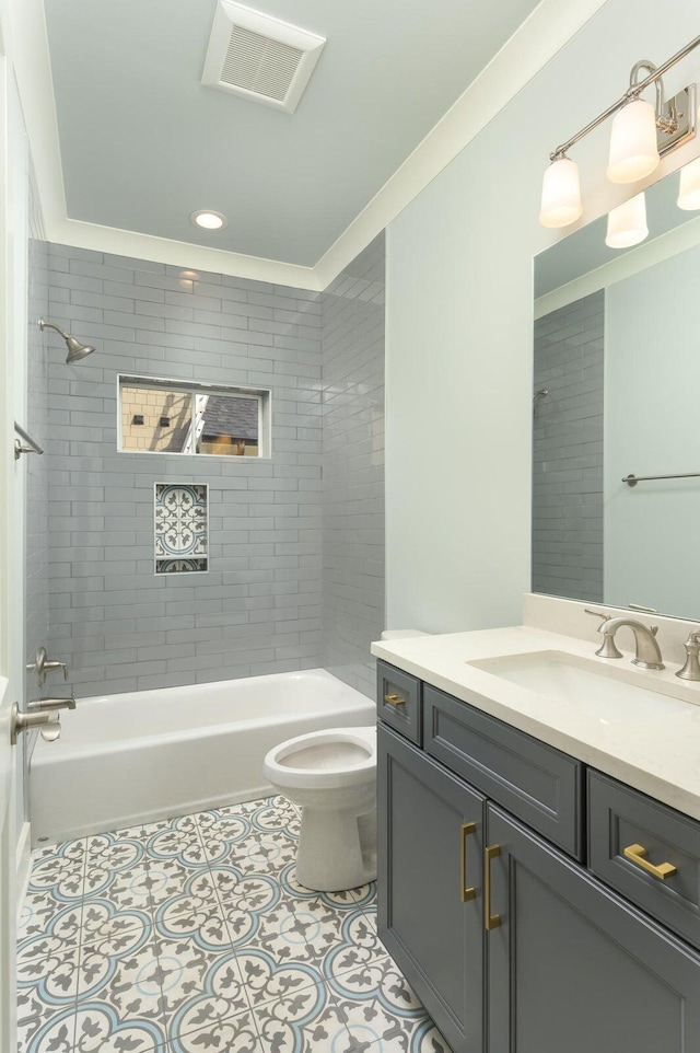 full bathroom with tile patterned floors, vanity, toilet, and tiled shower / bath combo