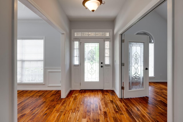 foyer entrance featuring a wealth of natural light, hardwood / wood-style flooring, and crown molding