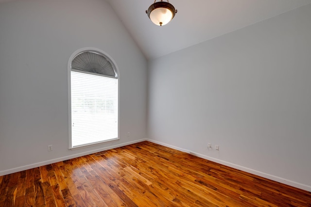 spare room with high vaulted ceiling and hardwood / wood-style flooring