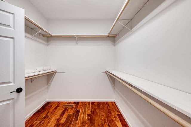 spacious closet featuring dark hardwood / wood-style flooring