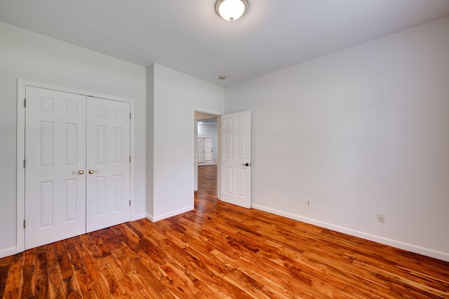 unfurnished bedroom with a closet and wood-type flooring