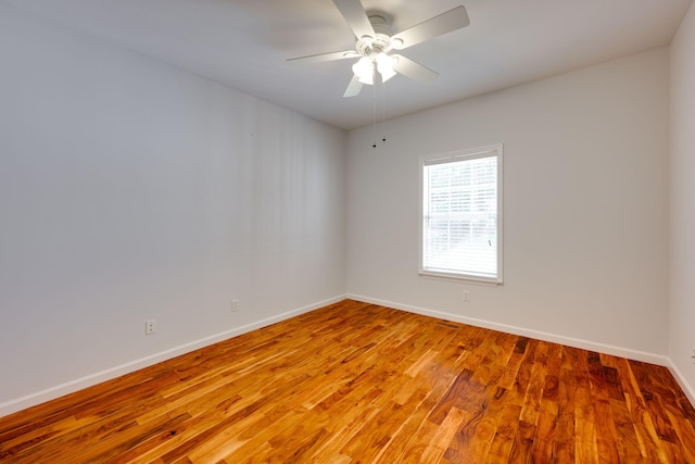 empty room with ceiling fan and hardwood / wood-style floors