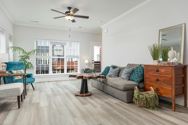 living room featuring a healthy amount of sunlight, ceiling fan, ornamental molding, and light wood-type flooring