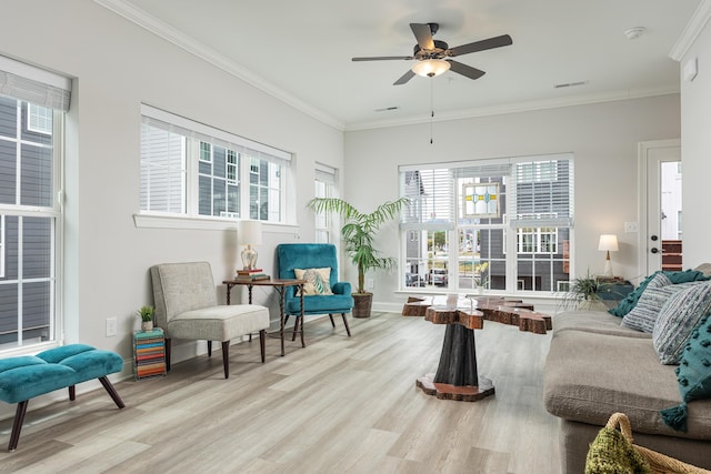 interior space with light wood-type flooring, ceiling fan, and crown molding