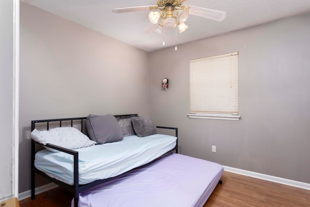 bedroom featuring a textured ceiling, ceiling fan, and dark hardwood / wood-style flooring