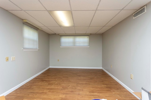 basement with light wood-type flooring and a drop ceiling