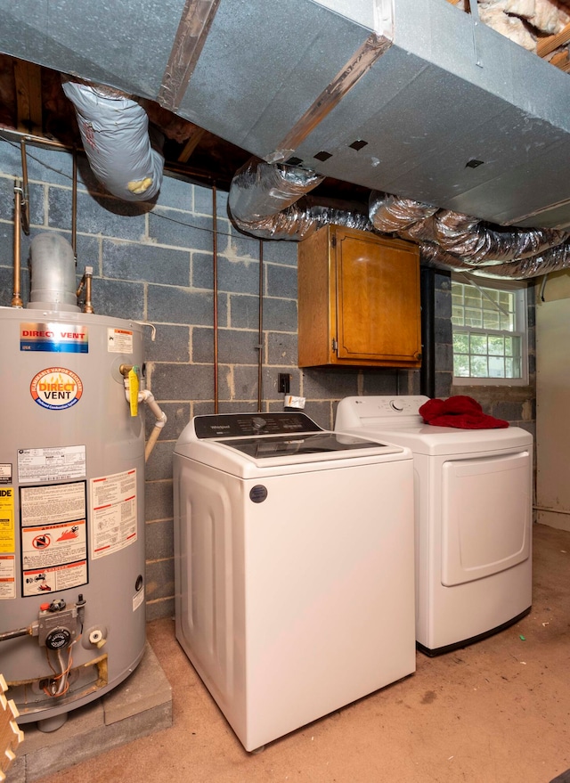 clothes washing area featuring cabinets, water heater, and washing machine and clothes dryer