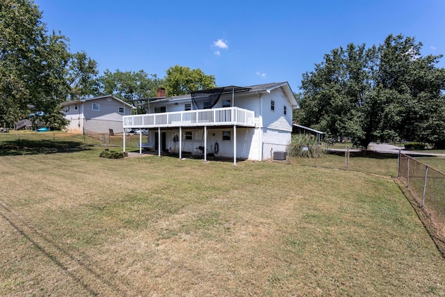 rear view of house with a lawn and a wooden deck