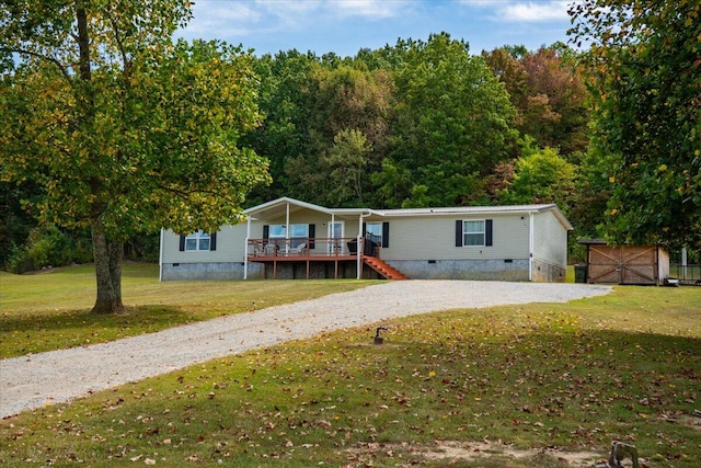 manufactured / mobile home with a front lawn and a deck