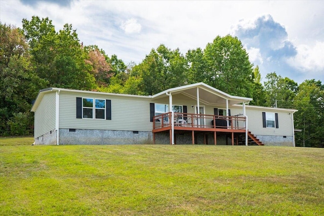 back of house featuring a wooden deck and a lawn