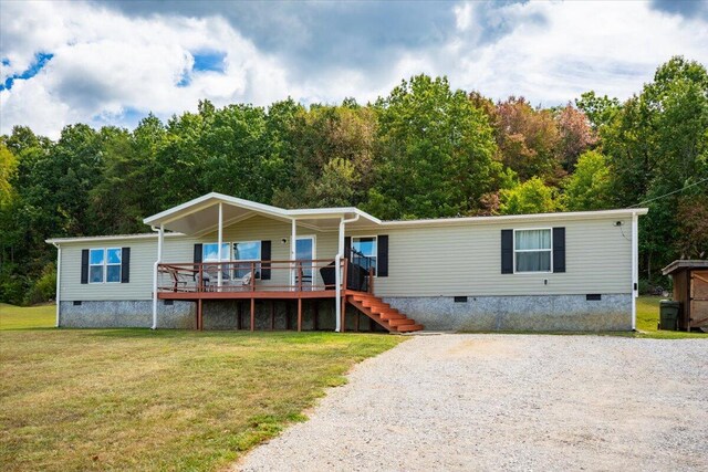 manufactured / mobile home with a deck and a front yard