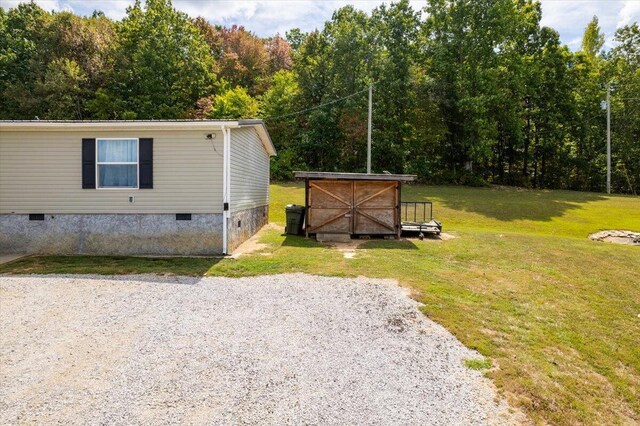 view of front of property with a storage shed and a front lawn