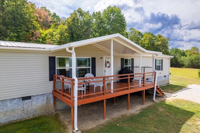 back of house with a lawn and a wooden deck