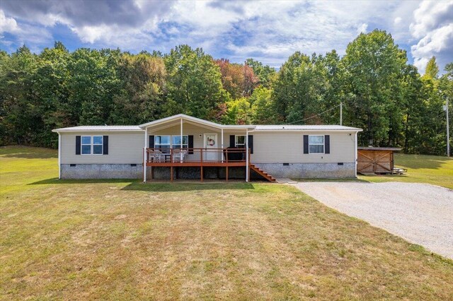 manufactured / mobile home featuring a deck and a front yard