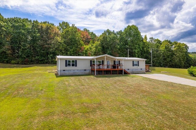 manufactured / mobile home with a wooden deck and a front lawn