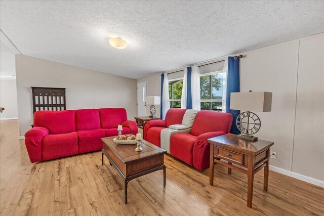 living room with light wood-type flooring and a textured ceiling