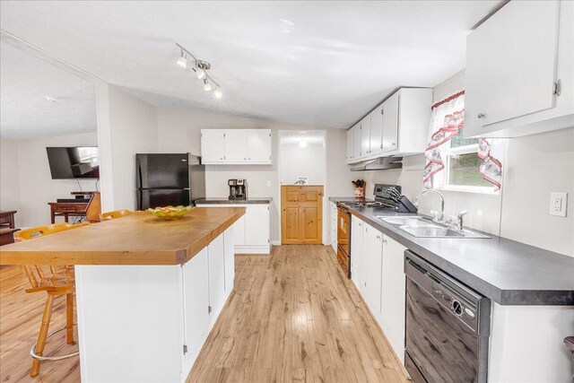 kitchen featuring vaulted ceiling, black appliances, sink, light wood-type flooring, and white cabinets