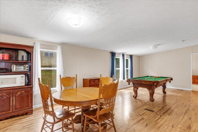 game room with billiards, light wood-type flooring, and a textured ceiling