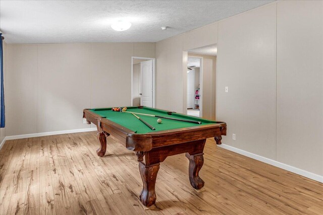 rec room with a textured ceiling, billiards, and light hardwood / wood-style floors