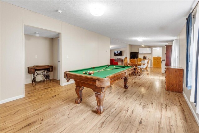 recreation room with pool table, a textured ceiling, and light hardwood / wood-style flooring