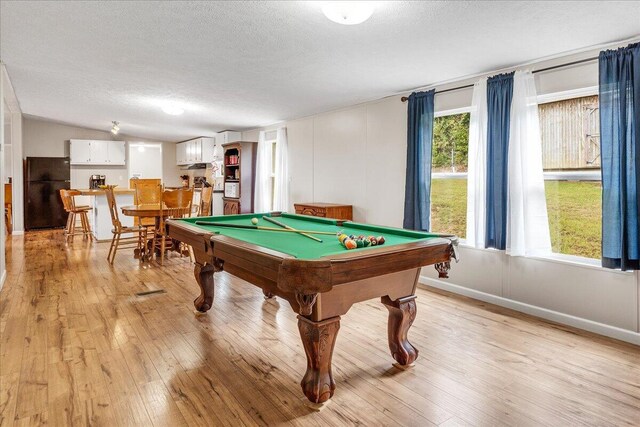 game room with a textured ceiling, pool table, and light hardwood / wood-style floors