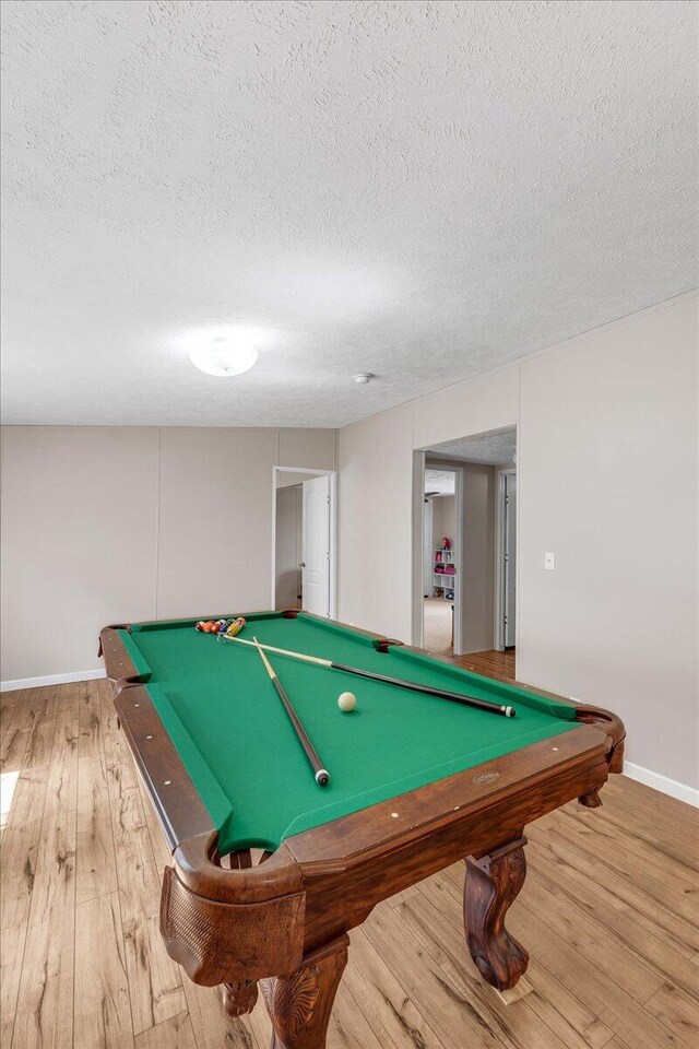 playroom with billiards, a textured ceiling, and light hardwood / wood-style flooring