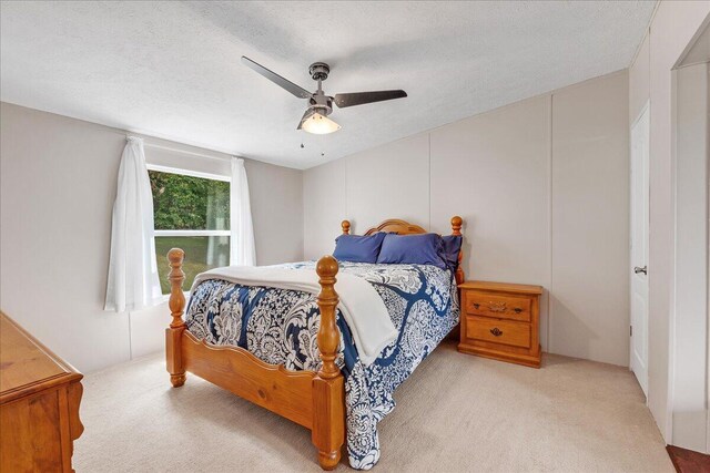 bedroom with a textured ceiling, ceiling fan, and carpet floors