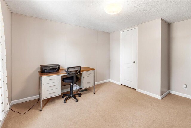 home office featuring light carpet and a textured ceiling