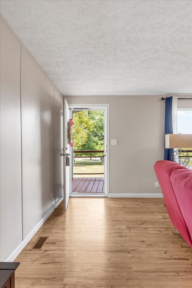 interior space featuring a textured ceiling and light hardwood / wood-style flooring