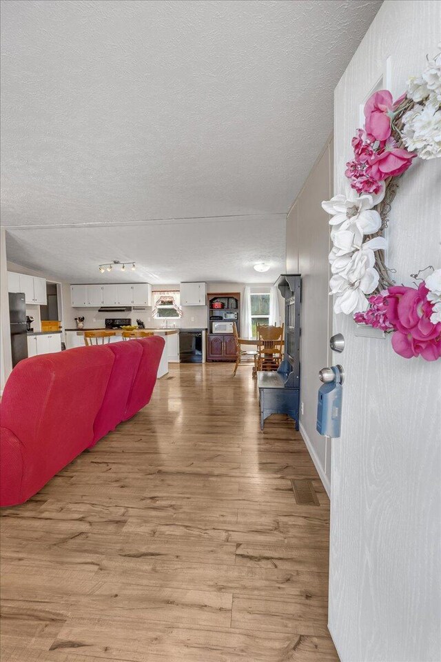 interior space featuring a textured ceiling and hardwood / wood-style floors