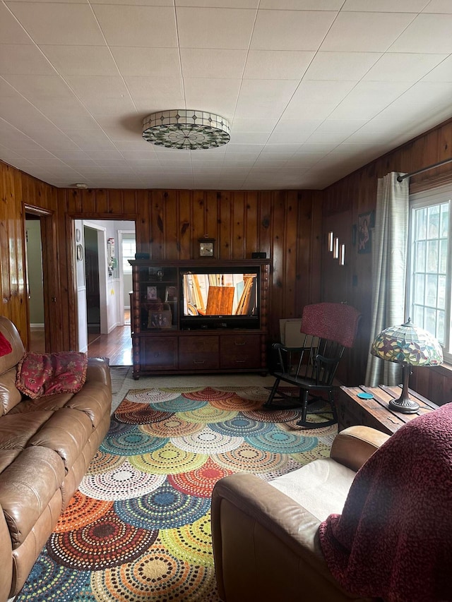 tiled living room featuring a wealth of natural light and wood walls