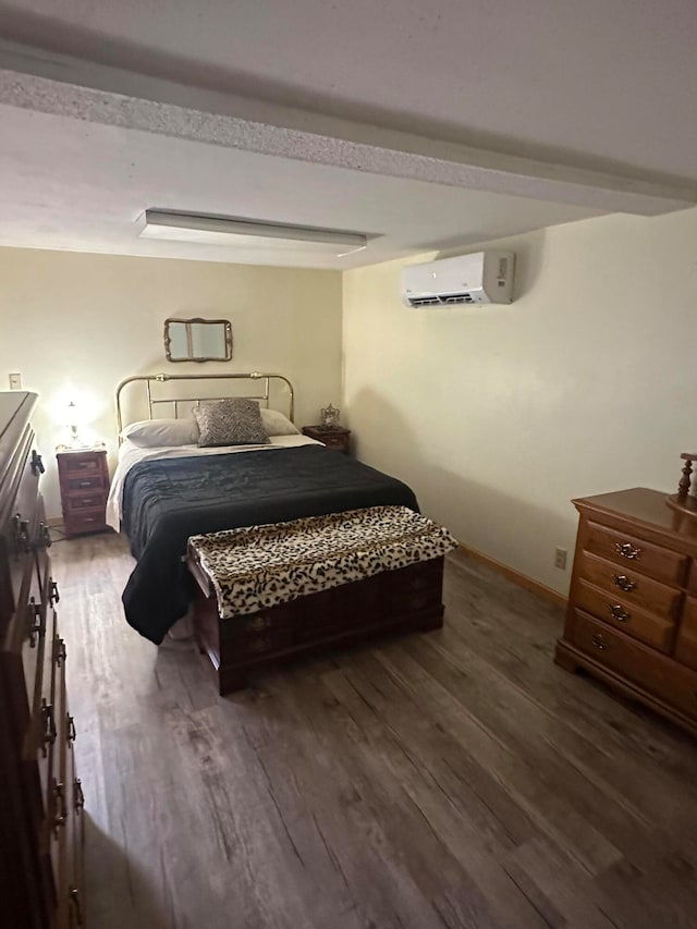 bedroom with dark hardwood / wood-style flooring and a wall unit AC