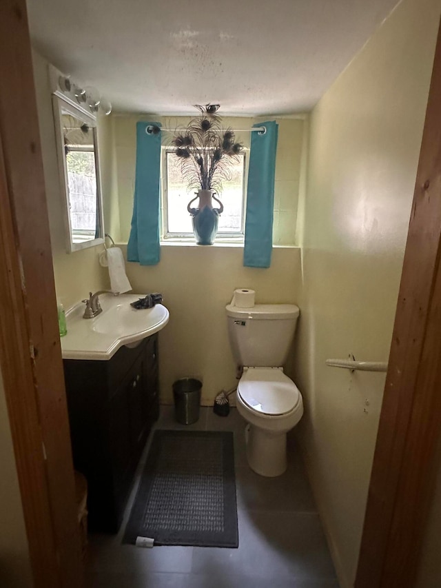 bathroom with vanity, toilet, and tile patterned floors