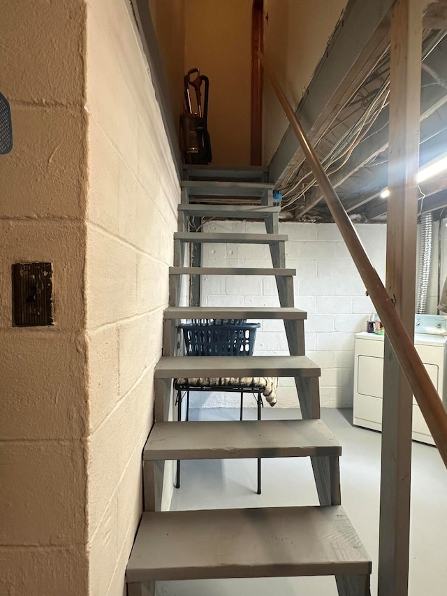 staircase with washer / dryer and concrete floors