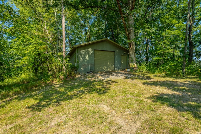 view of yard with a garage and an outbuilding