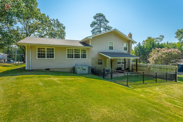 rear view of property featuring a lawn and central AC