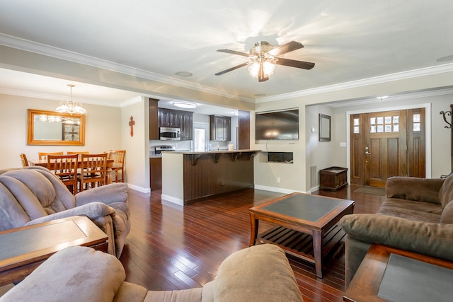 living room with ceiling fan with notable chandelier, dark hardwood / wood-style flooring, and crown molding